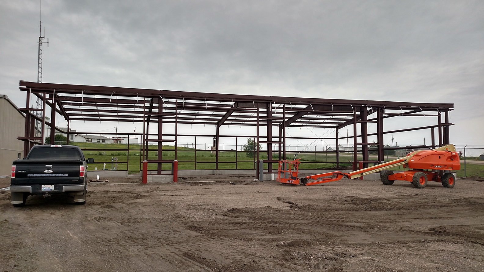 Summit Contracting crews erecting steel building with 4 overhead doors.
